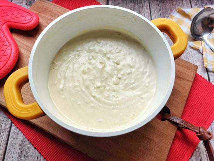 Panela com molho de queijo parmesão.