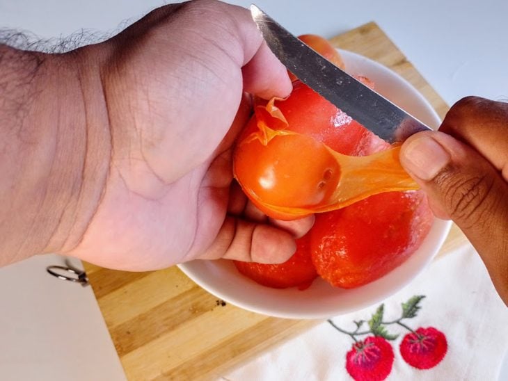 Um tomate sendo descascado.