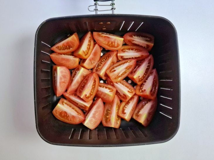 Pedaços de tomate acomodados no cesto da Air Fryer.
