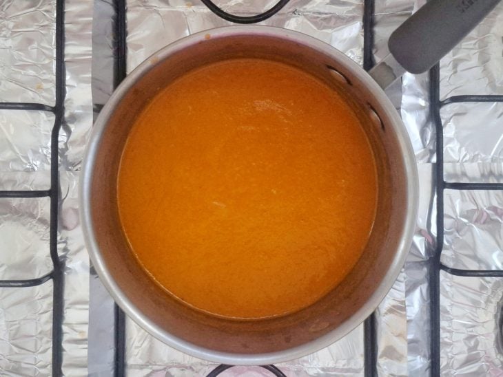 Molho de tomate do liquidificador despejado na panela e temperado com sal e pimenta-do-reino.