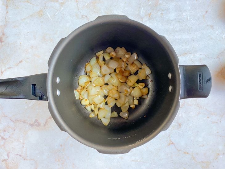 Uma panela de pressão com alho a dourar.