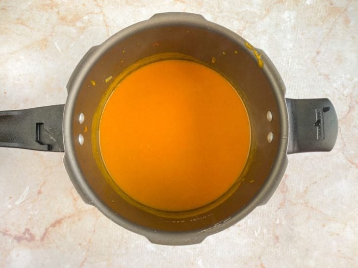 Molho coado e temperado na panela de pressão.