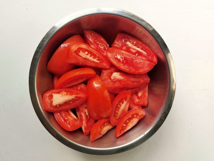 Um recipiente contendo tomates cortados.