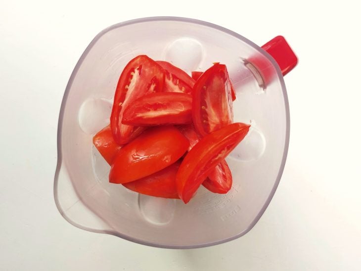 Um liquidificador contendo tomates cortados.