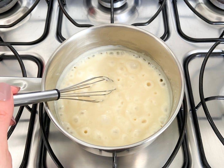 Uma panela com a mistura de roux com leite.