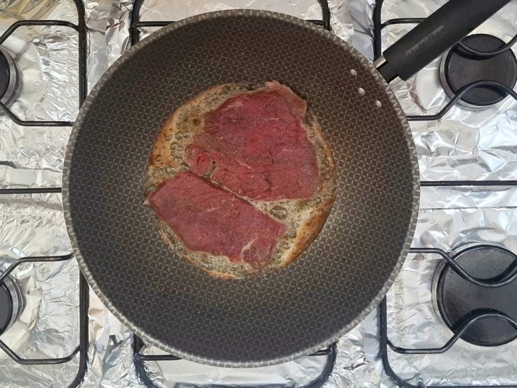 Frigideira ao fogo com os bifes.