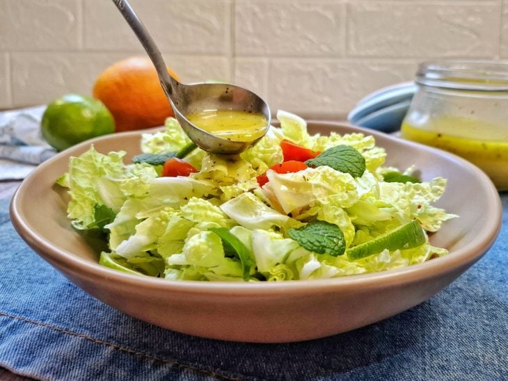 Molho para salada tropical com limão sendo despejado.