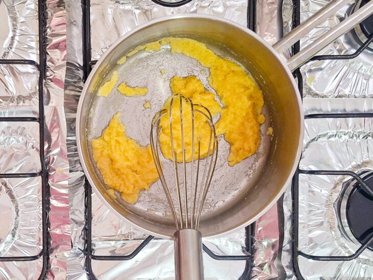 Manteiga e farinha sendo misturadas em uma panela até formar uma pasta homogênea.