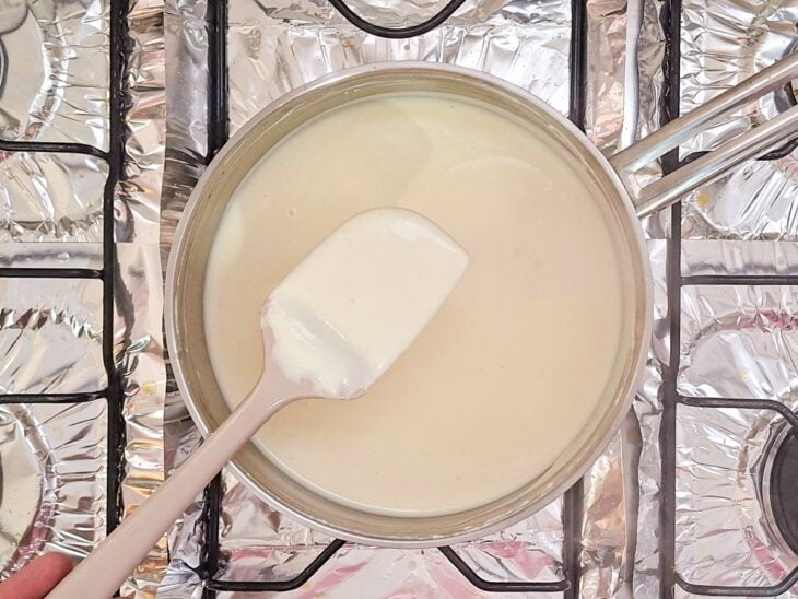 Molho branco cozinhando com folhas de louro até engrossar.