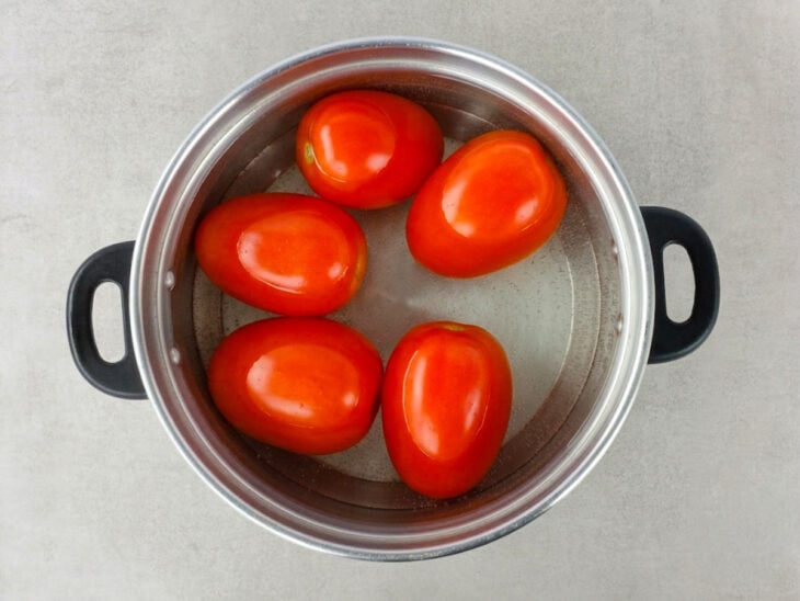 Tomates sendo mergulhados em água fervente para facilitar a retirada da casca.