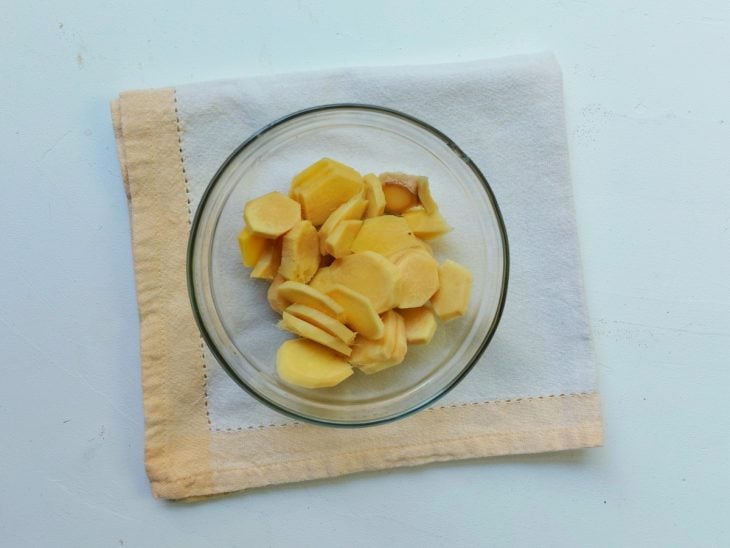 Um recipiente contendo gengibre cortado em rodelas.