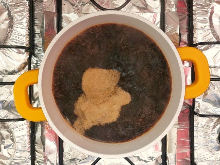 Uma panela contendo a mistura de vinagre, shoyu e açúcar, fervendo.