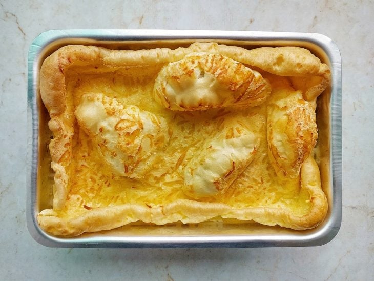 Preparação sendo retirada do forno já dourada e inflada.