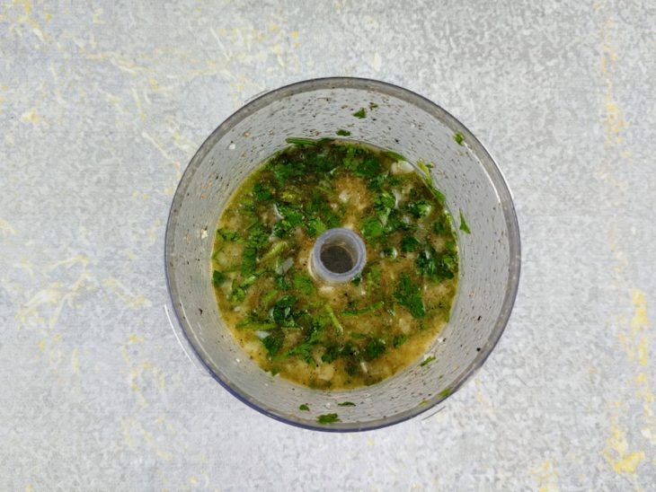 Um multiprocessador com cebola, alho, salsinha, sal, pimenta-do-reino, azeite, suco do limão.