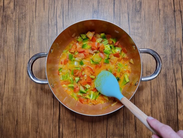 Legumes e temperos refogados na panela com caldo.