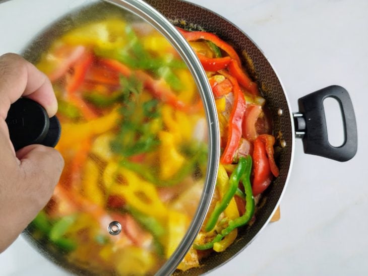 Panela com a moqueca sendo tampada.