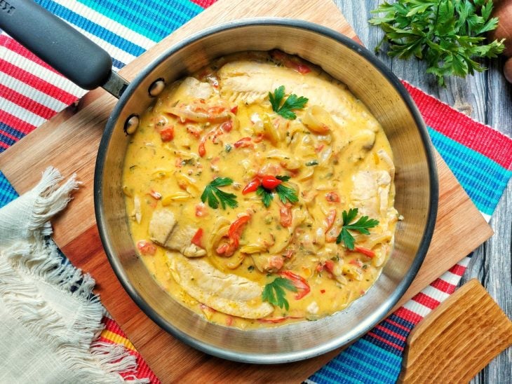 Uma panela contendo moqueca de tilápia fácil.