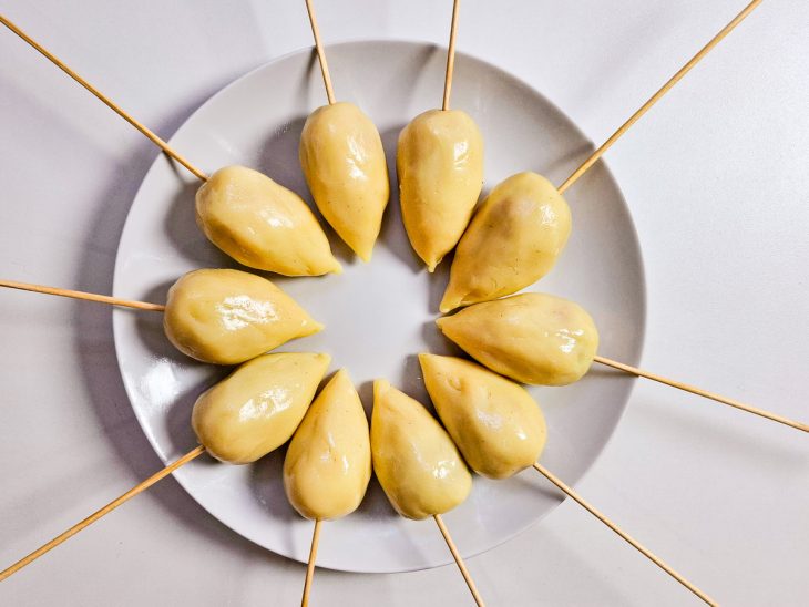 Morangos cobertos pelo brigadeiro com espetos.