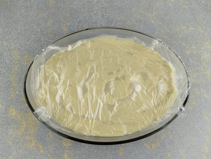 Creme na travessa com plástico em contato.