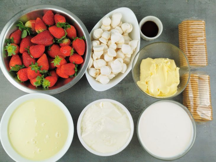 Ingredientes organizados na bancada com morangos inteiros separados.