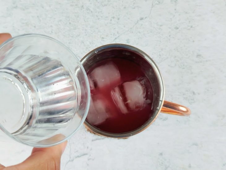 Caneca com a mistura do chá e vodka, água, suco de limão, açúcar e gelo.