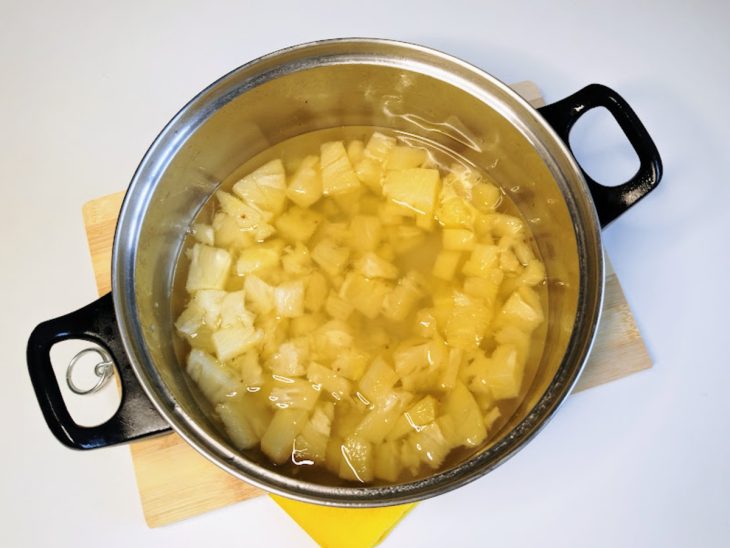 Uma panela com pedaços de abacaxi cozidos.