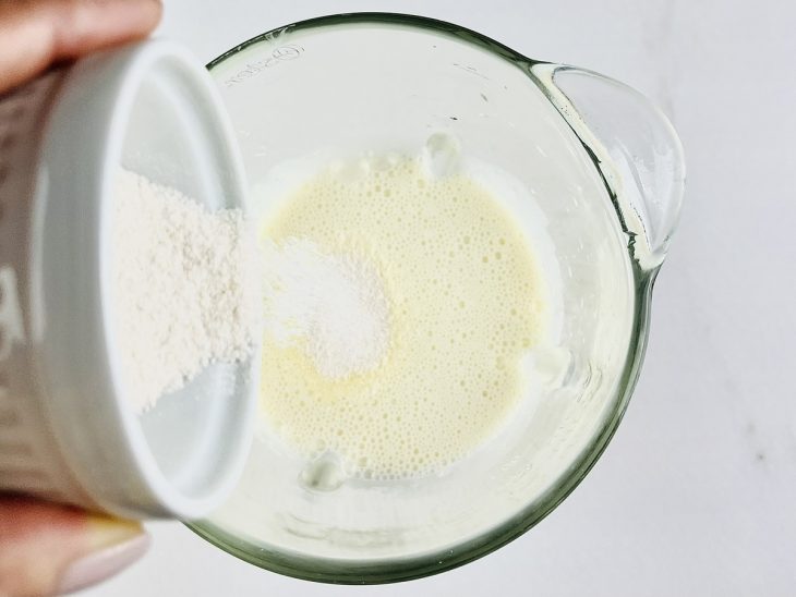 Suco em pó sendo adicionado.