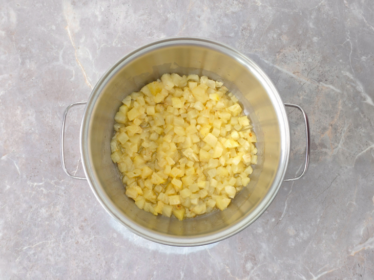 Água quente sendo adicionada ao abacaxi já cozido.