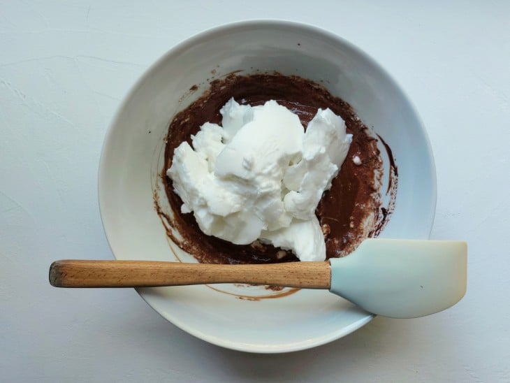 Um recipiente contendo ganache e claras em neve.