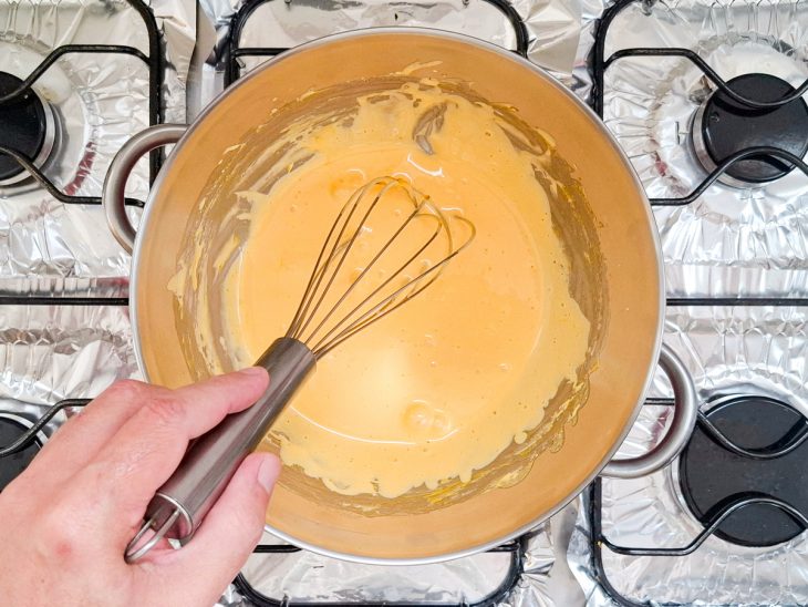 Numa tigela, em banho-maria, as gemas com metade do açúcar.