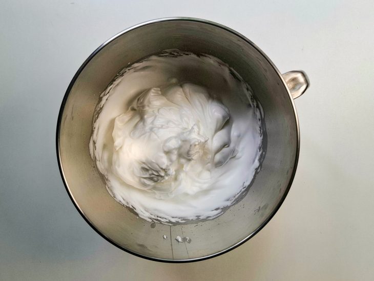 Numa tigela, claras batidas em neve junto ao açúcar.