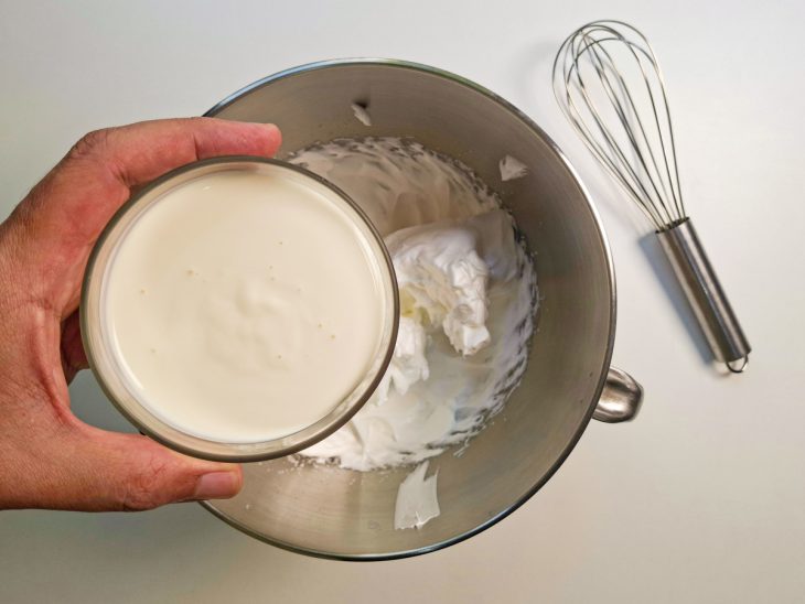 Creme de leite num recipiente para ser adicionado na clara em neve batida na batedeira.