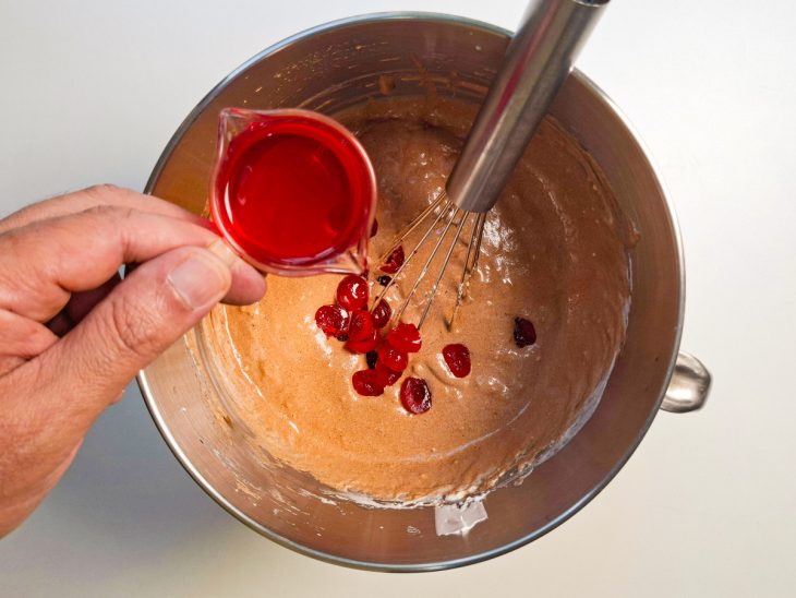 Calda de cereja, cerejas e conhaque adicionados na tigela.