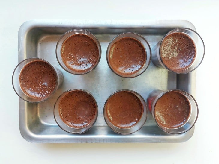 Mousse de chocolate distribuída em recipientes individuais.