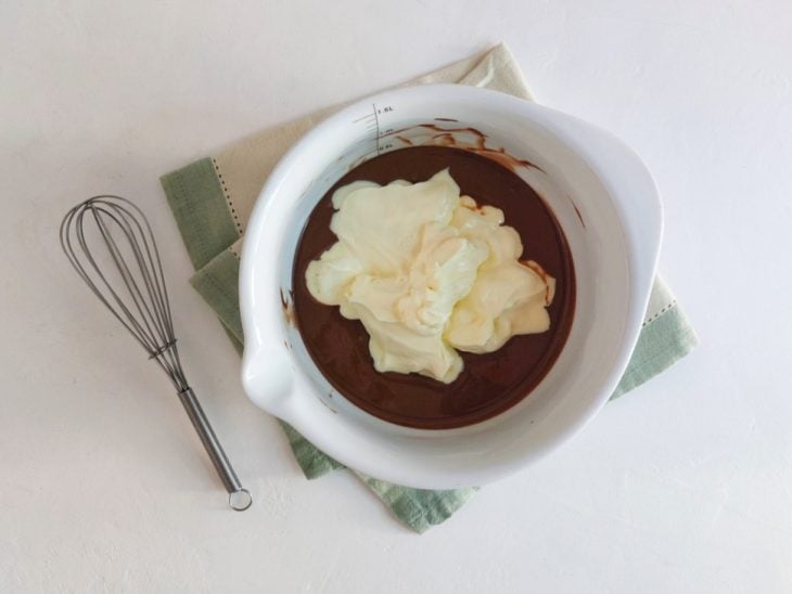 Creme de leite colocado na tigela com o chocolate derretido.