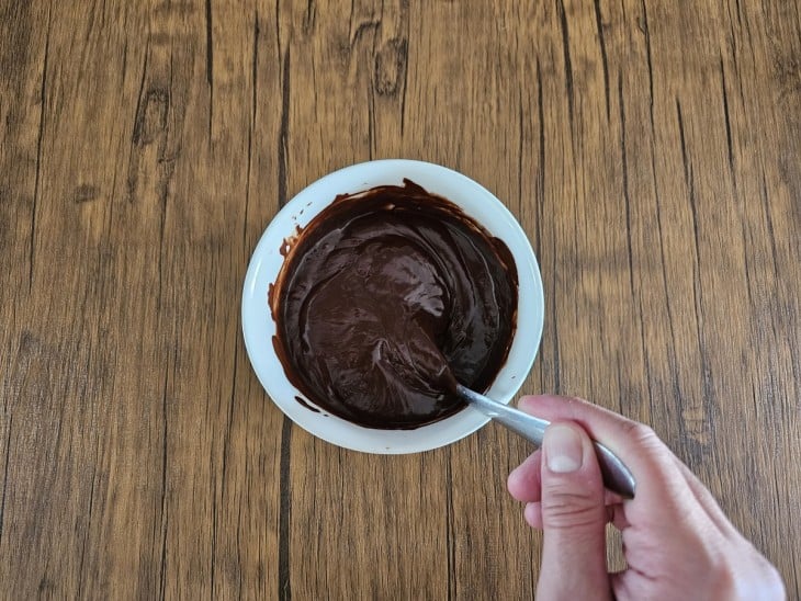 Um recipiente com a mistura de chocolate derretido e leite condensado.