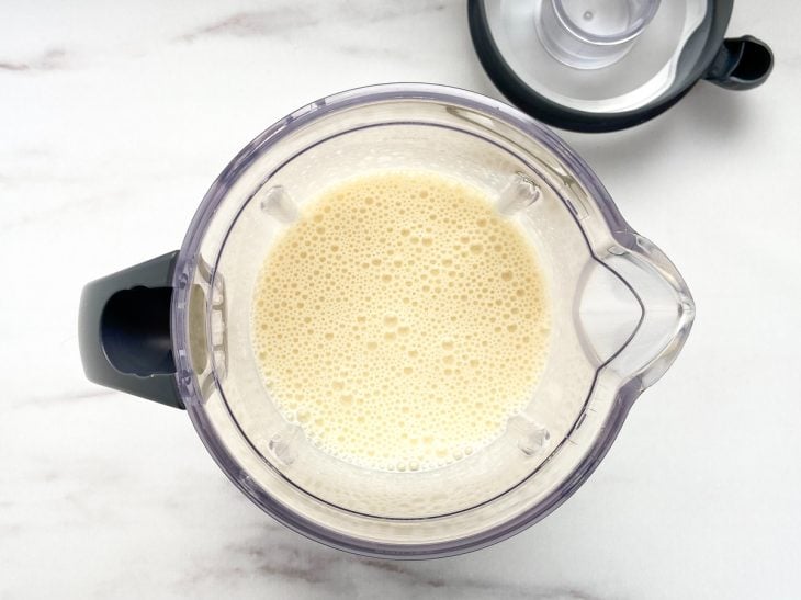 Um liquidificador contendo a mistura de creme de leite, leite condensado, leite em pó e gelatina.