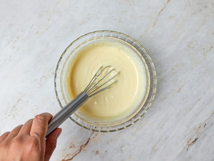 Na tigela, a mistura do chocolate com creme de leite, acrescida do leite em pó.