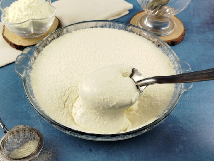 Mousse pronta na travessa, uma colher tirando uma porção.