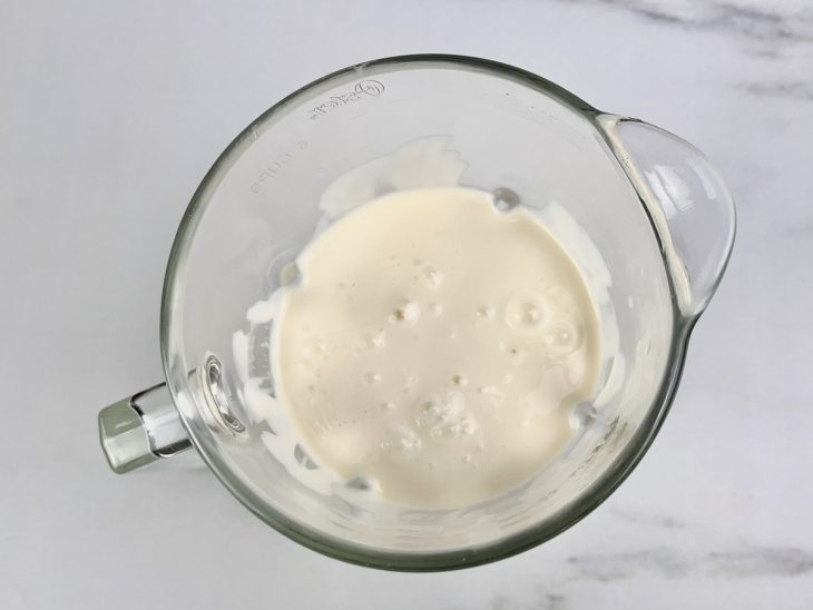Creme de leite e leite condensando batidos no liquidificador.