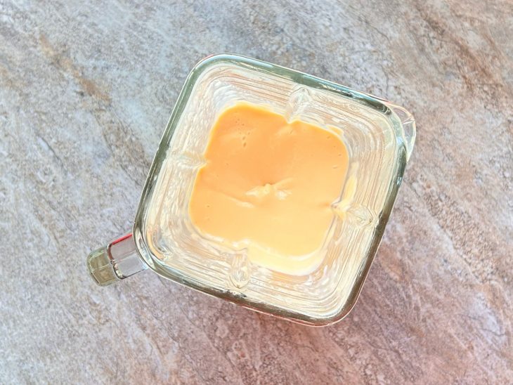 No liquidificador, o creme de leite, o leite condensado e o suco em pó batidos.