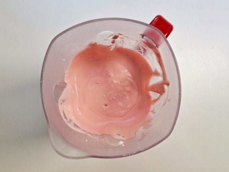 Creme de leite, chantilly, leite condensado e suco de morango batidos no liquidificador.