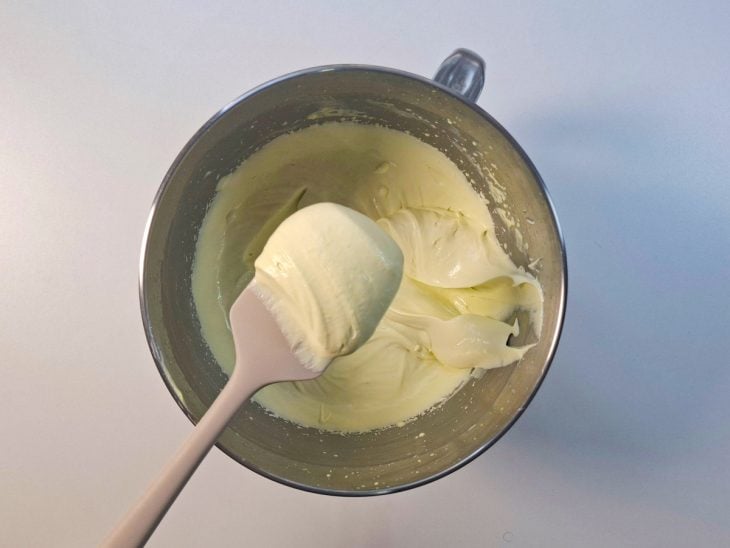 Suco em pó sendo adicionado à mistura e mexido vigorosamente.