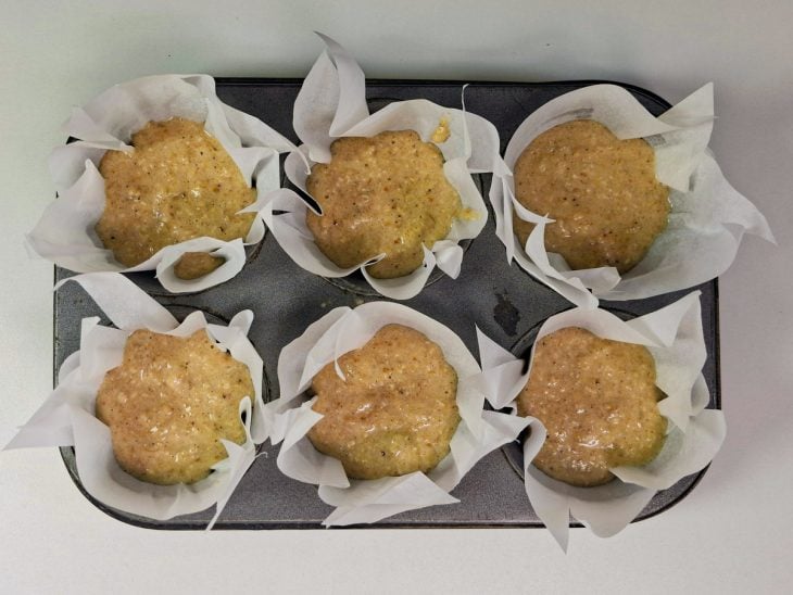 Massa sendo distribuída nas forminhas de cupcake.
