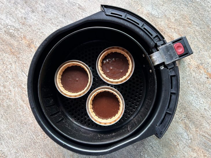 Forminhas com massa colocadas no cesto da air fryer.