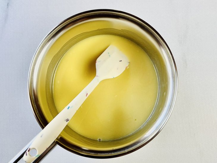 Creme de leite fresco, manteiga e glucose misturados em uma panela.