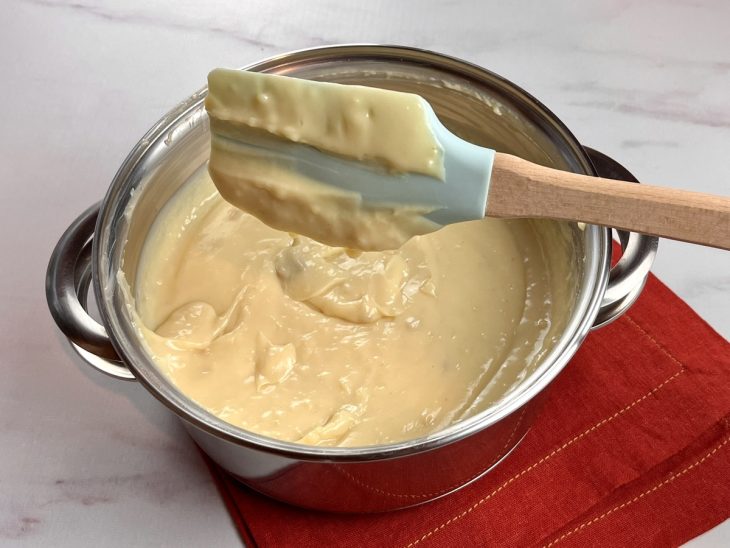 Uma panela contendo a mistura de leite condensado, leite em pó e manteiga.