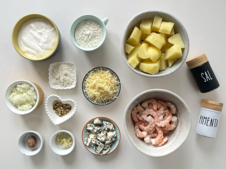 Ingredientes organizados na bancada com as batatas cozidas e os camarões limpos.