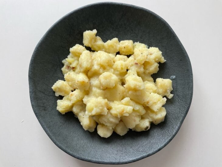 Massa de batata moldada em pequenas bolinhas iguais sobre a mesa.