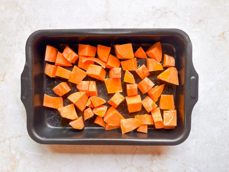 Pedaços de abóbora em uma assadeira retangular.